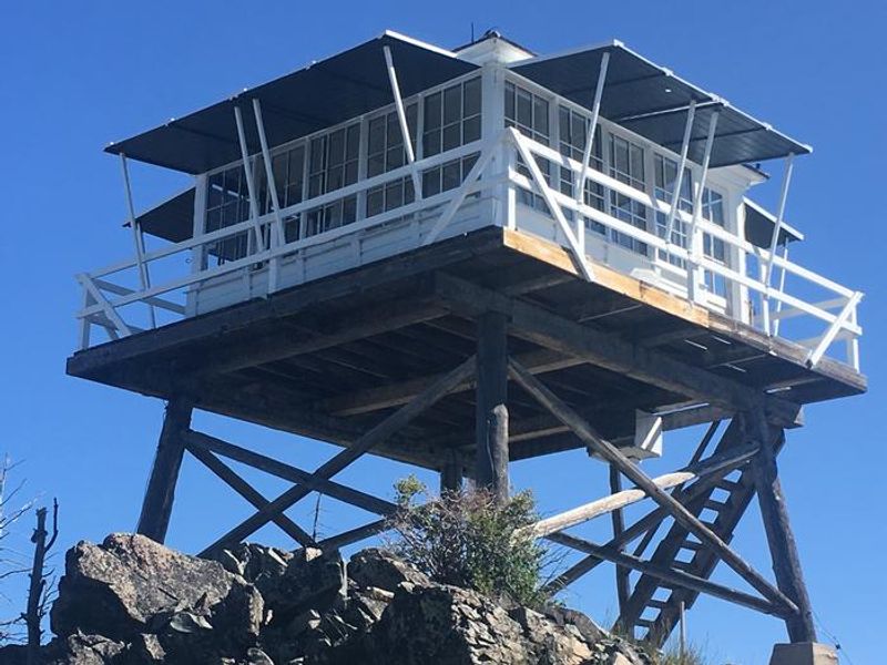 A fire lookout sets on top a mountain
