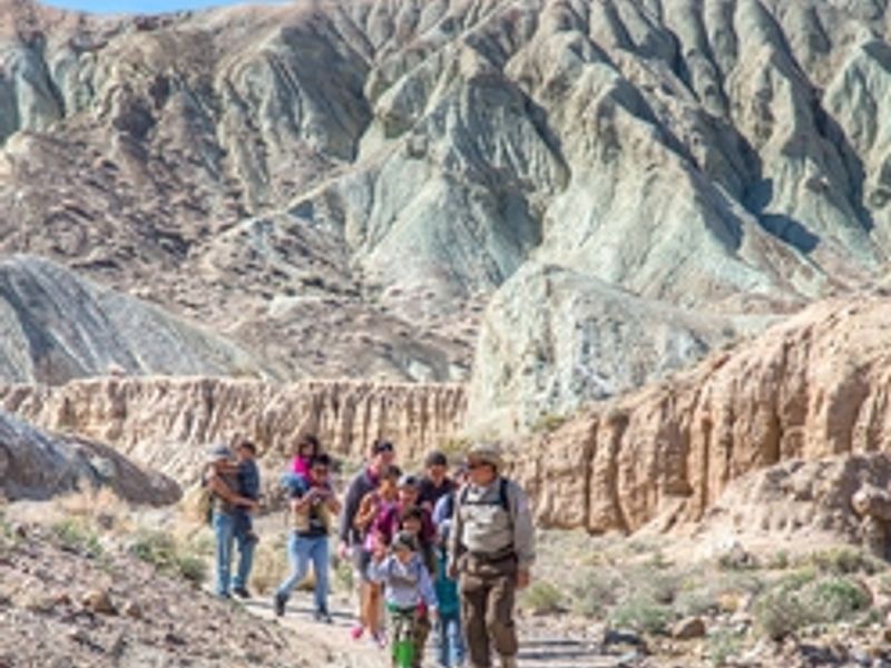 A group walks on a trail in the Rainbow Basin Natural Area.