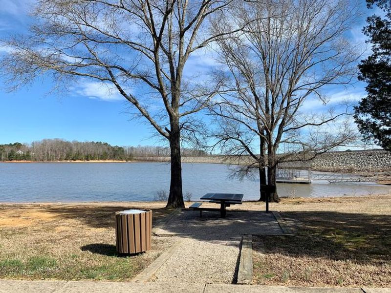 This is an accessible picnic area with a picnic table and trash can. 