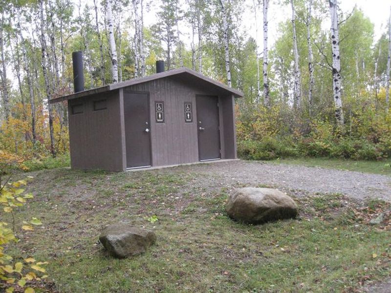 Outhouse toilet building in a campground loop.