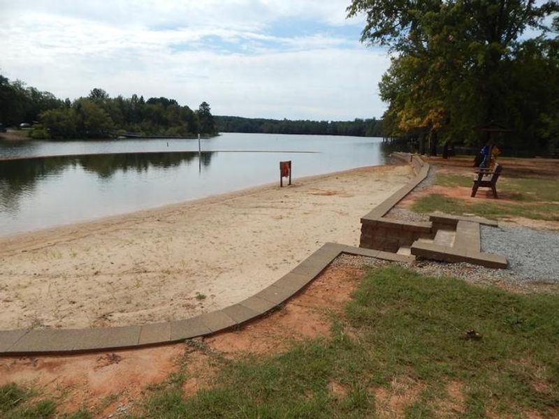 This is a photo of the designated swimming area at Longwood Park. There are steps that take you to a nice sandy beach. Not pictured is a life jacket loaner station with a variety of different size life jackets for your convenience to borrow and return. 