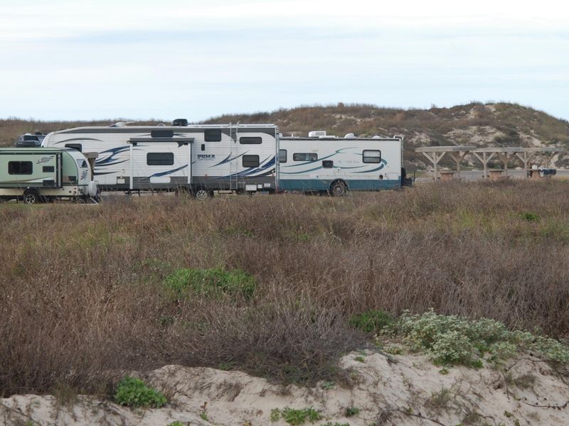 All gravel sites are in a row that back up to a grass-covered dune with the gulf behind it.