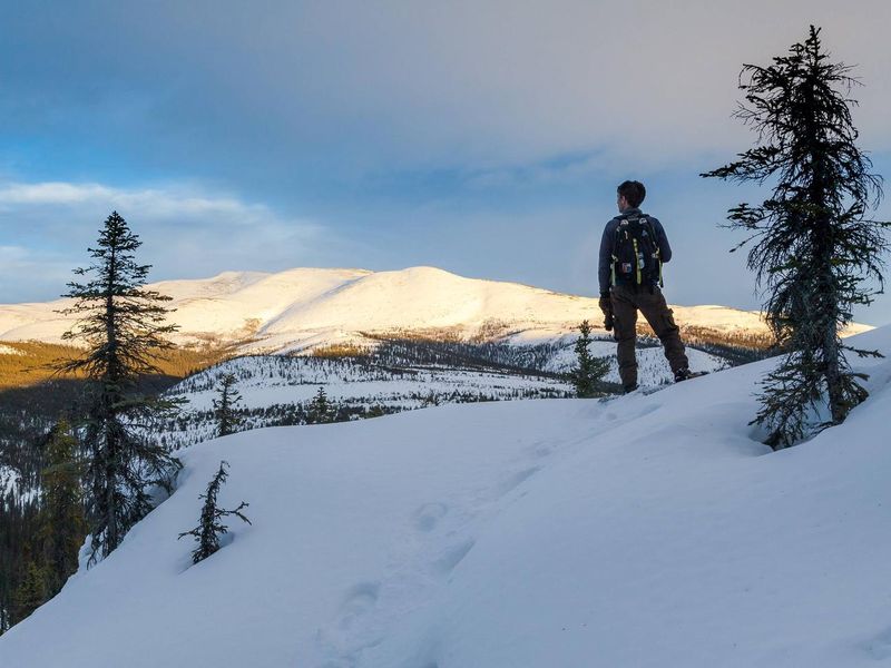 A snowshoer enjoys an evening view of the Fossil Creek drainage near Windy Gap in the White Mountains National Recreation Area.