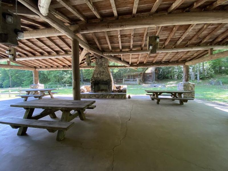 Picnic tables and a fireplace are located underneath the pavilion.