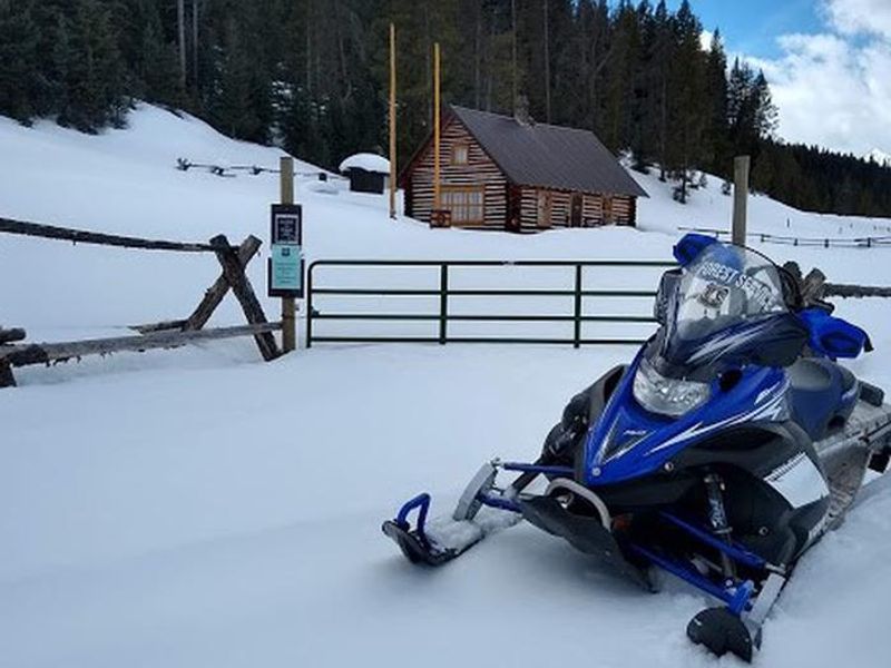 Snowmobile in front of cabin gate