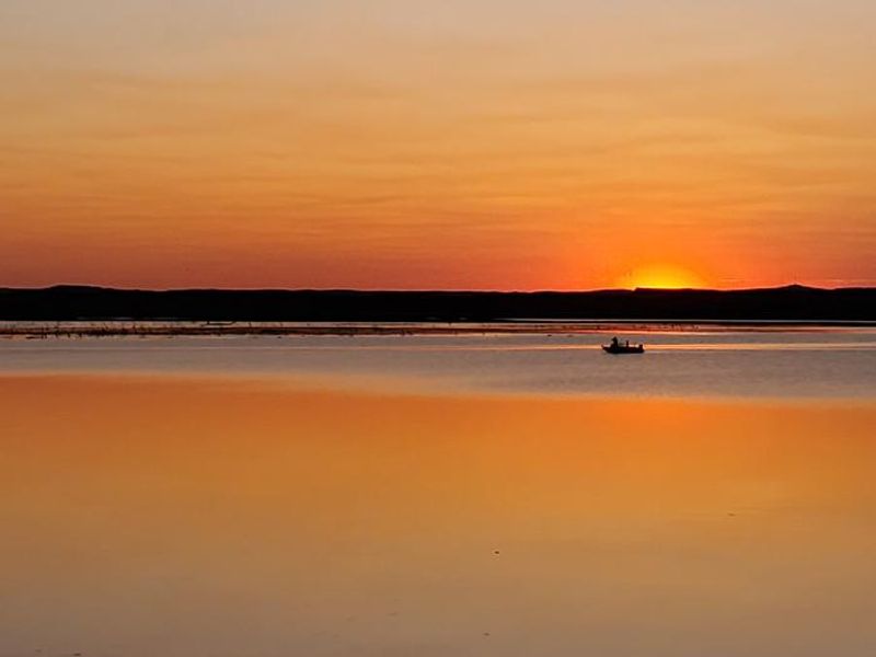 A lone fisherman out looking for walleye at sunset on Lake Oahe at Hazelton Recreation Area.