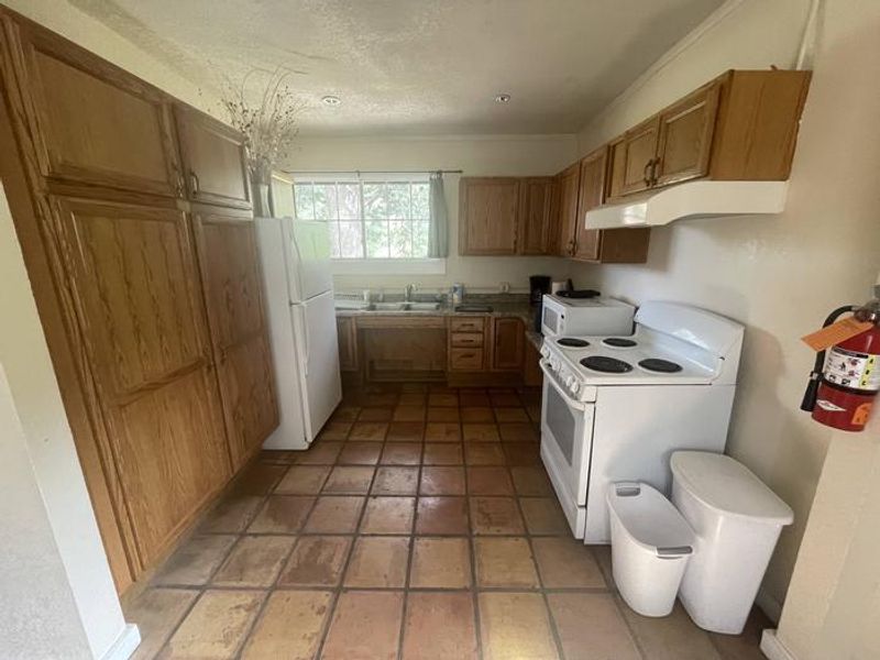 Kitchen of Portal CCC House, outfitted with stove/oven, fridge, microwave, and coffee machine.