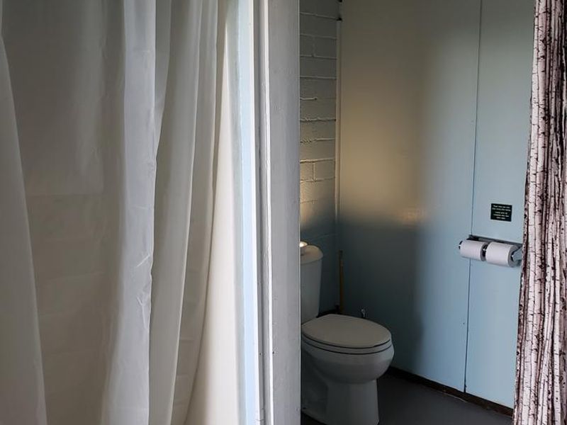 Bathhouse interior showing shower and flush toilet.  Open from mid- May to mid- October