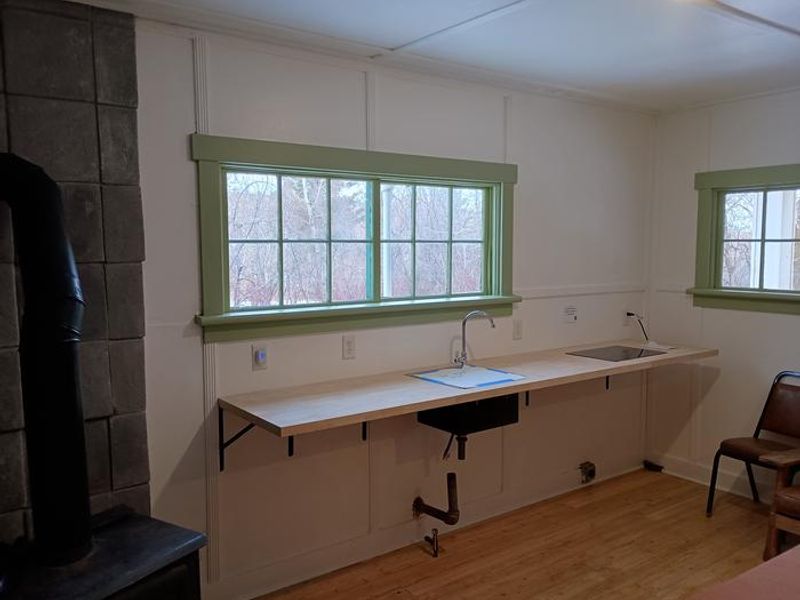 Cabin rental includes an electric stovetop, cooking prep area and dining table. 