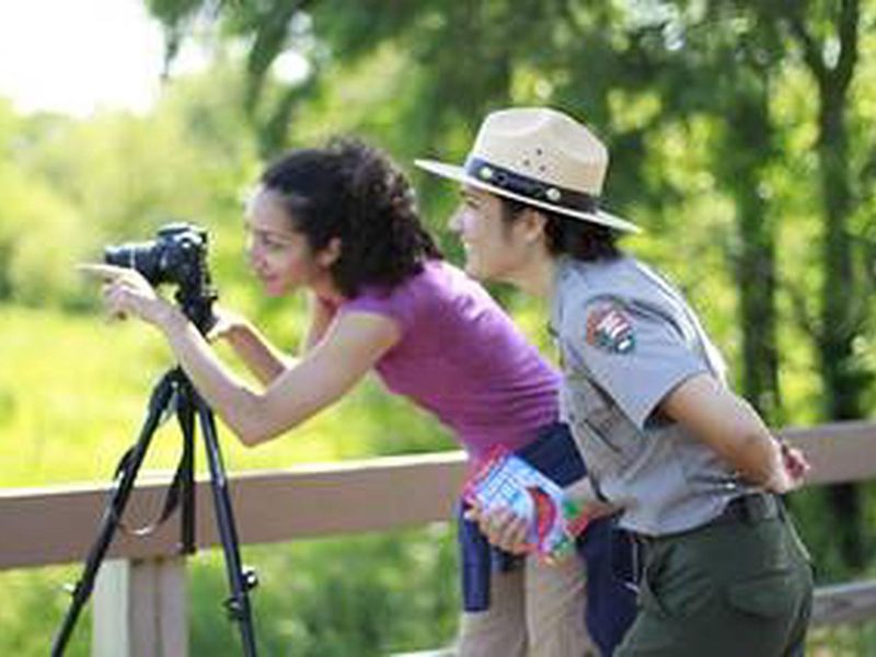 A park ranger and visitor looking at birds in the Great Marsh are in the Indiana Dunes National Park.
