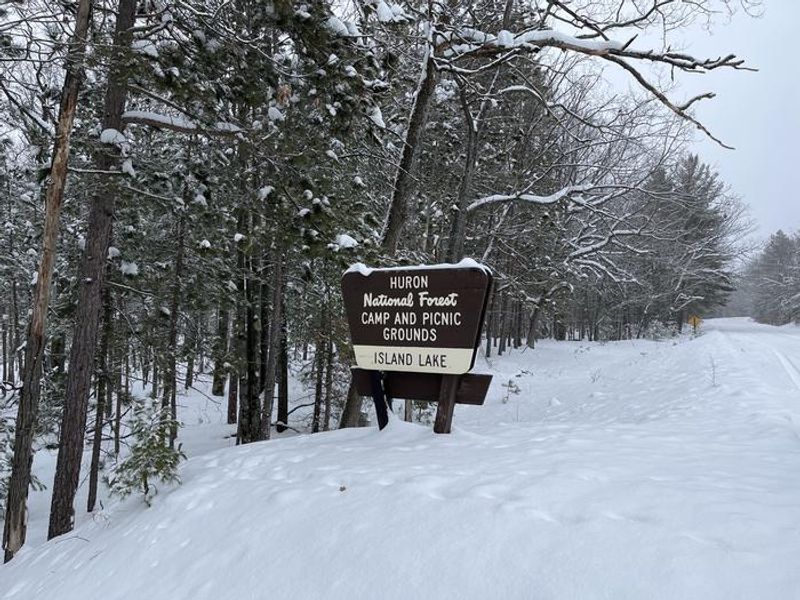 A snowy photo of Island lake (MI) sign 