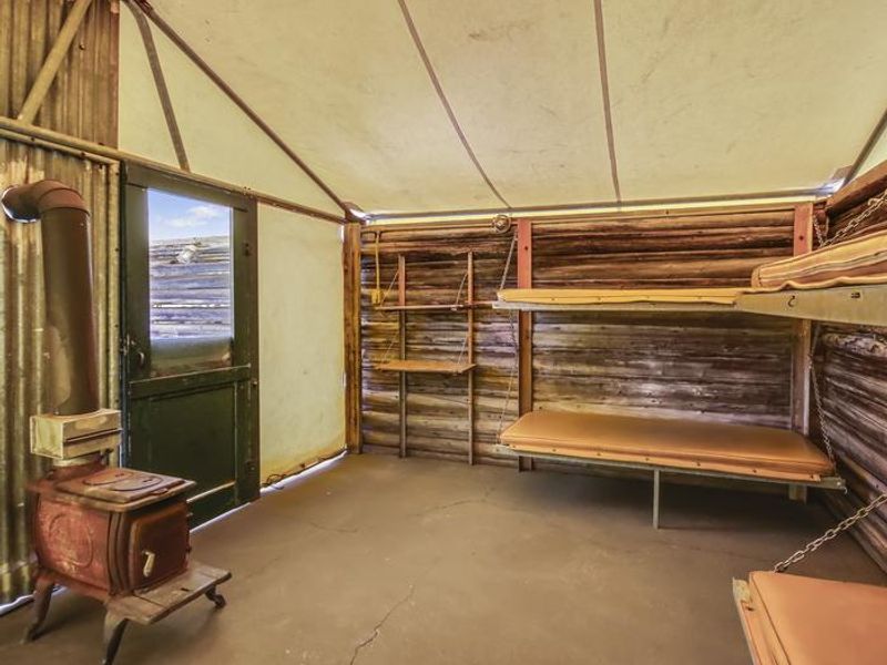 The Tent Cabin includes two sets pull-down bunk beds for a total of four beds with padding, an interior potbelly wood burning stove for heat, and lighting. While the bunks are padded, sleeping bags and pillows not included.