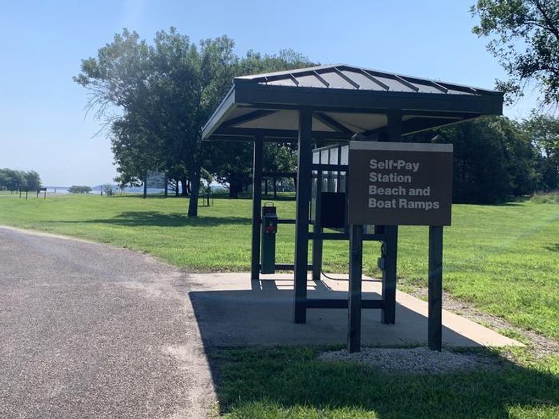Self-Pay Station for Day Use visitors using the beach and boat ramp located across the entrance flagpole.