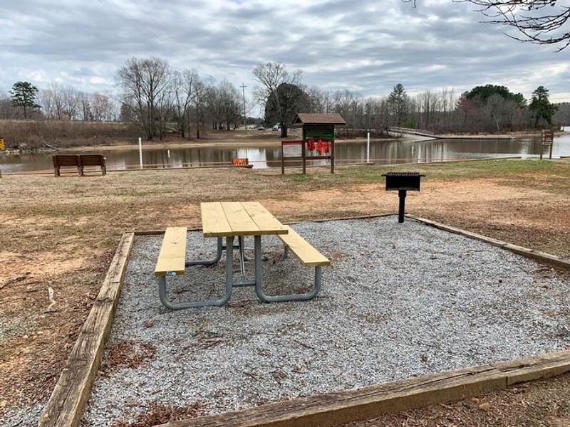 This is a timbered picnic site. This site is located in the day use area at Longwood Park Day Use Area. There is a picnic table and a grill within the timbers. There are trash cans located throughout the day use area.