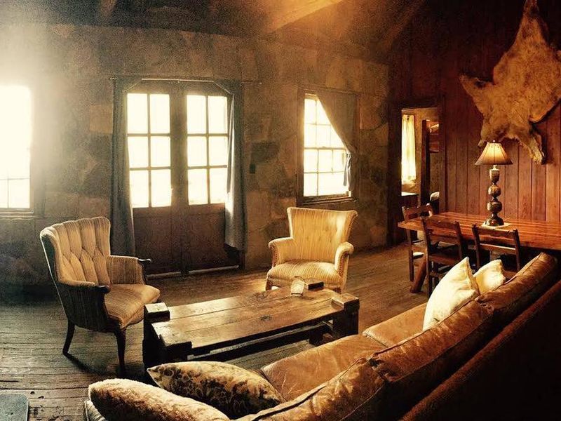 Cabin A's living room is beautifully furnished, features a large rock fireplace and walls, comfortable and unique!