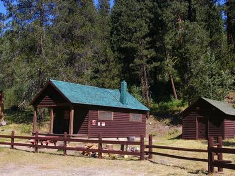 Deer Park Cabin features a nice porch with a roof and a water pump house.