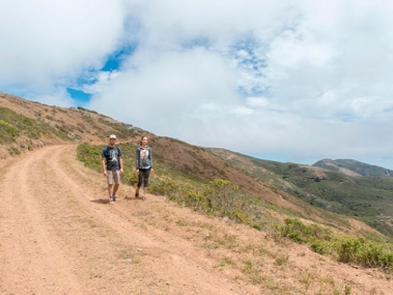 Two hikers walk the fire road.