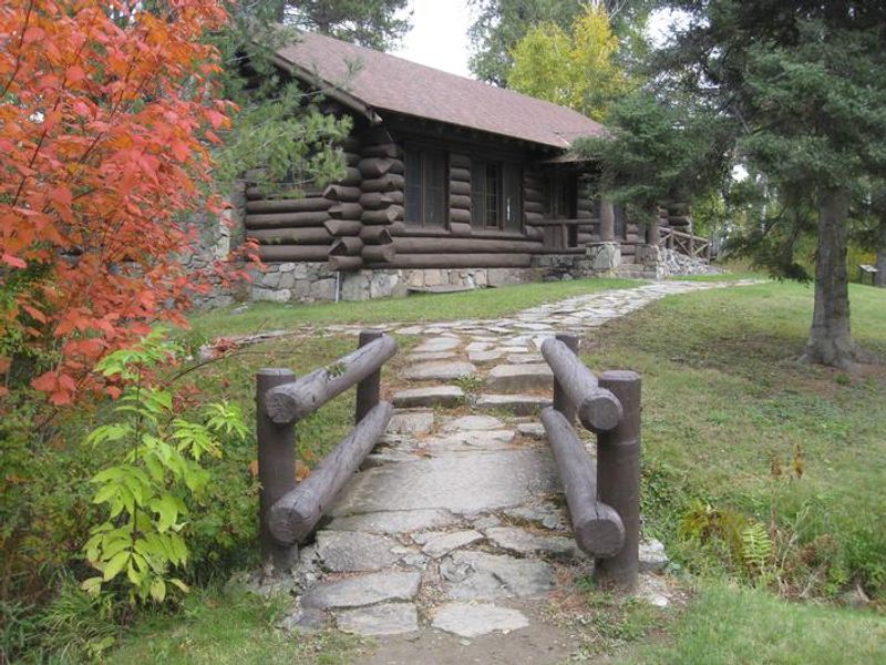 Access trail to log pavilion.  Pavilion is available for rent via recreation.gov.  Facilities include indoor tables, benches, and electricity.  Outdoor facilities include grill, picnic tables, open grassy area, parking, and outhouse.