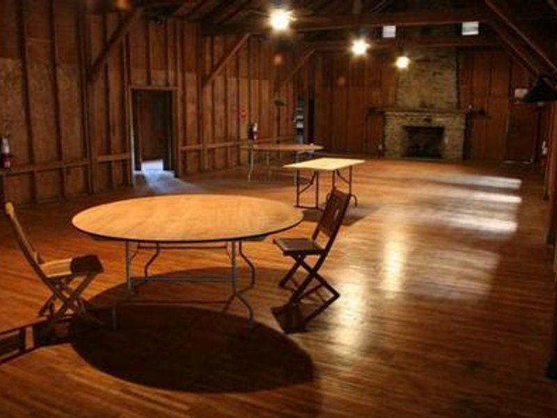 Table and chairs in main room of Appalachian Club House with gas fireplace in background