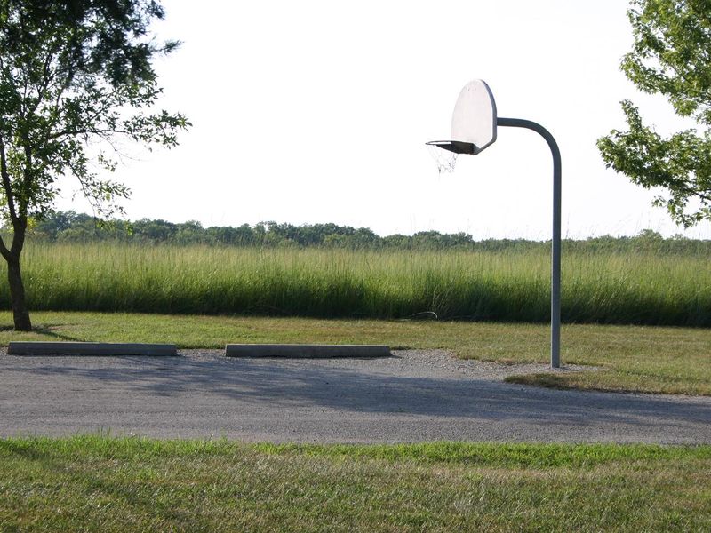 A basketball goal is located near the parking area for the group camp