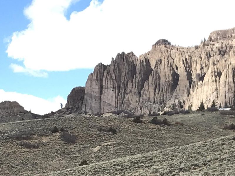 Dillon Pinnacles, a rock formation, basks half in the sunlight and half in the clouds. The Dillon Pinnacles Trail and Overlook are not far from Red Creek Campground