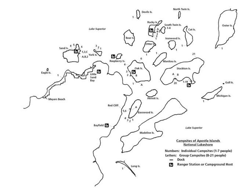 A black & white image of the islands and mainland within Apostle Islands National Lakeshore. The islands have numbers and letters indicating the location of those sites. There is a legend on the bottom right of the screen explaining the letters and numbers, along with dock and ranger or campground host images for the key. 