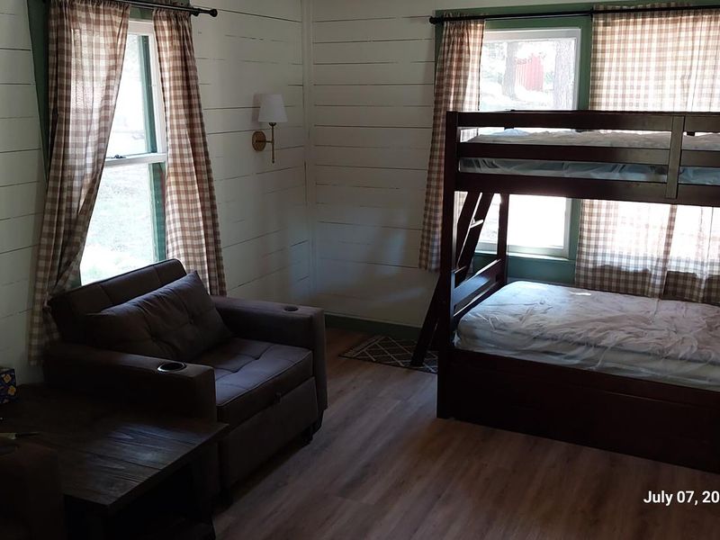 Bunk beds and chairs in main living area. Front door, not pictured, is to the right of the bunk beds.