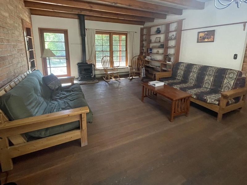 Living room of Half Moon Ranch furnished with futons, chairs, and games/puzzles.