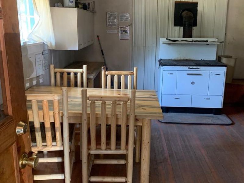 White stove used for cooking and heat source.  Stove does not generate as much heat as a wood stove/fireplace.