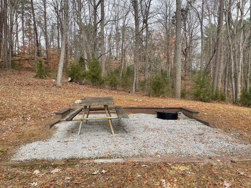Welcome to Grassy Creek! This is a photo of one of the many picnic sites available at Grassy Creek. Each picnic site has a table and a grill. There are trash cans located nearby to dispose of trash properly. 