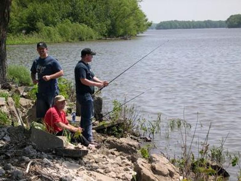 Three men fishing from shoreline.