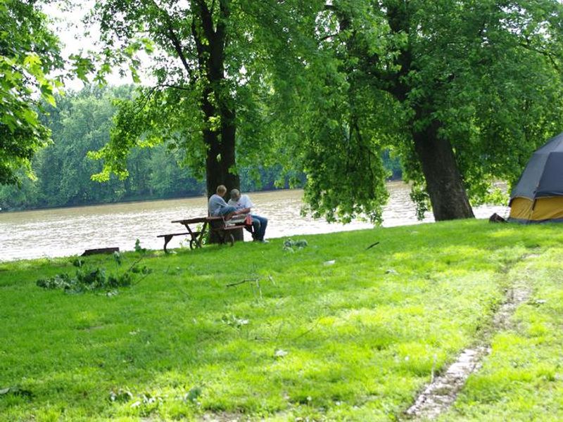 Father/Son on table along river with tent