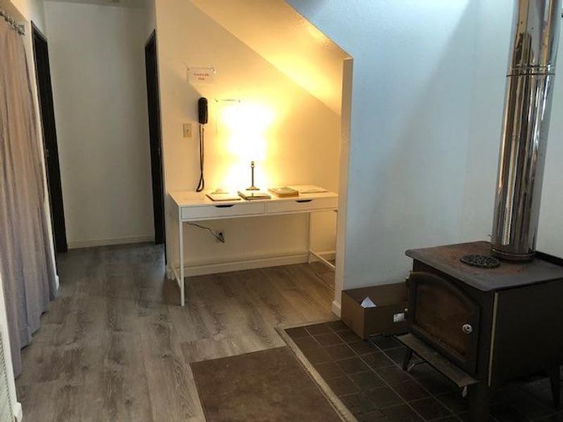 Living Room #3, facing east. Washer and dryer on the left behind grey curtain. Woodstove on the right