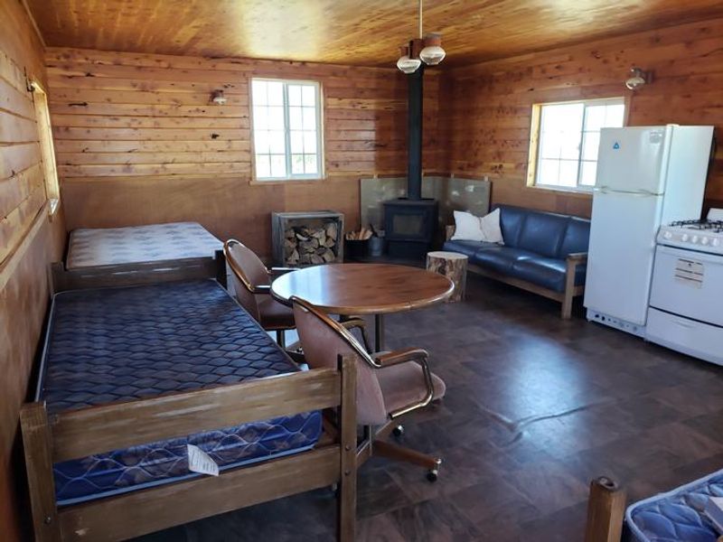 Interior View of Queen Bed, Two Twin Beds, Couch, and Wood Stove