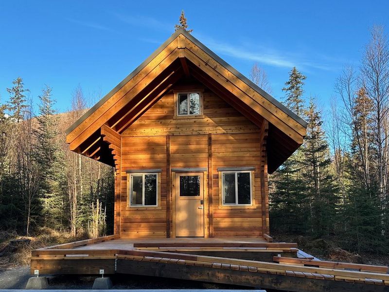 Two-story log cabin with large front porch and ramp.  