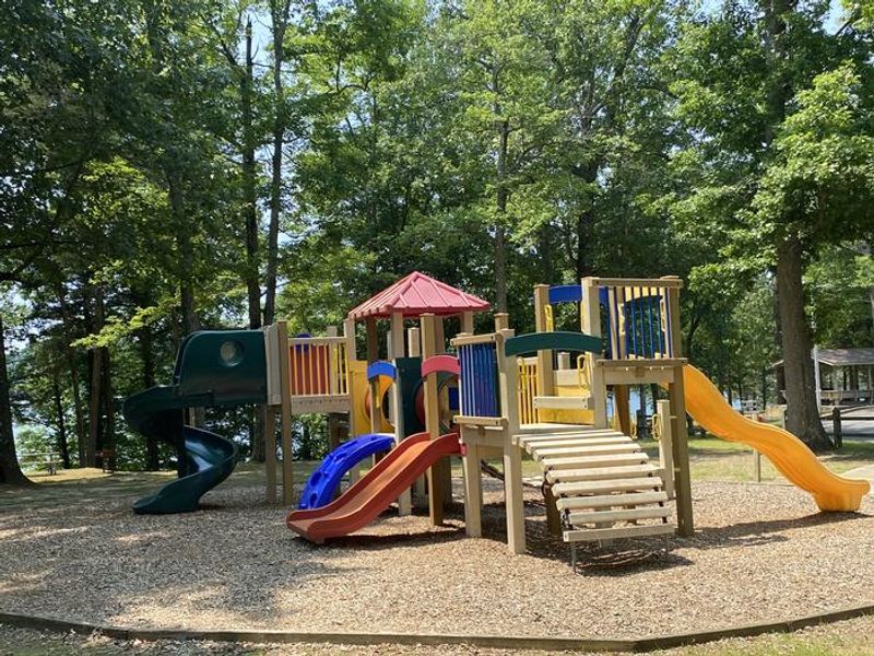 A photo of facility CUMBERLAND POINT CAMPGROUND with Picnic Table and playground. 