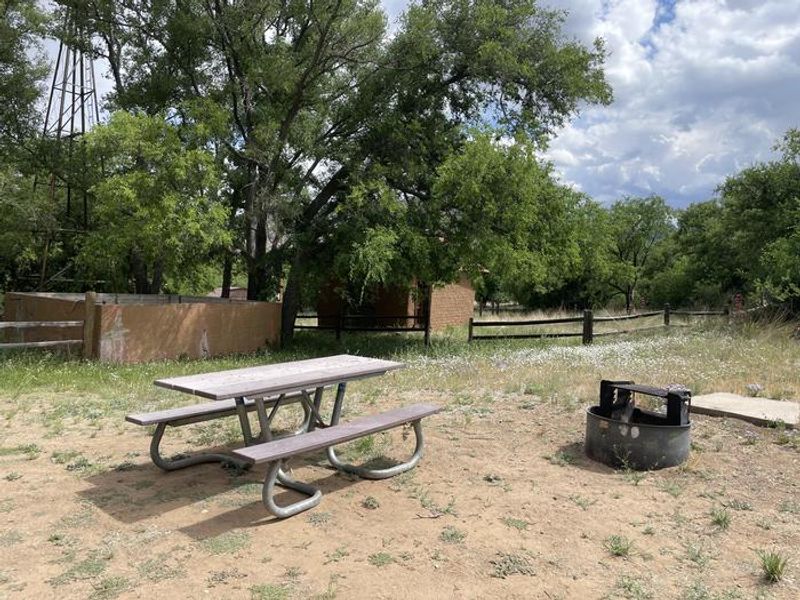 Sideyard of Half Moon Ranch with picnic table and fire ring.