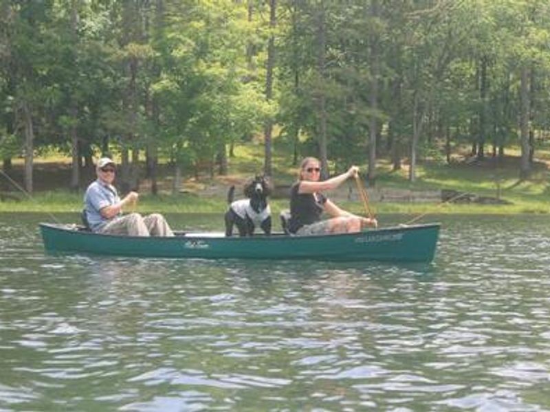 Couple taking dog for a ride in a canoe