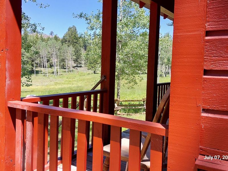 Front porch of Guard Station with view of adjacent meadow.