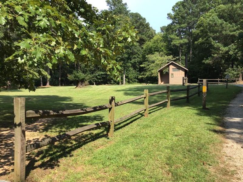Entrance to Sedalia Campground with vault toilet and centrally located water spigot.