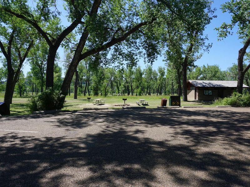 Parking area with the restroom and picnic tables in the distance