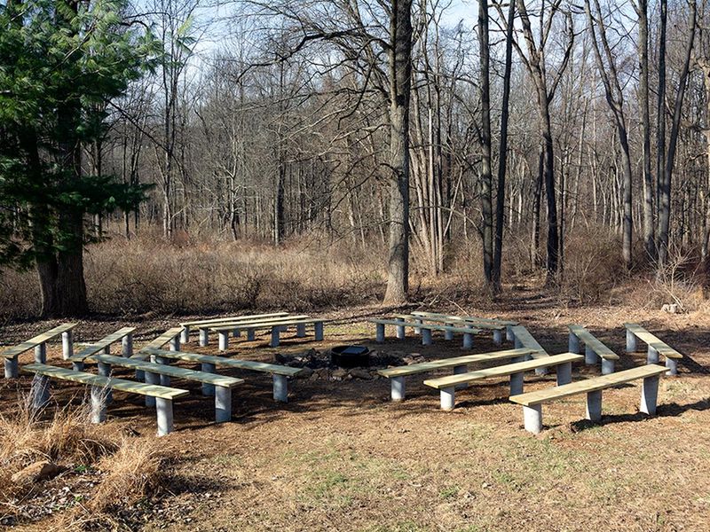 The peaceful outdoor fire circle has 18 new wooden benches and a wood shed.  