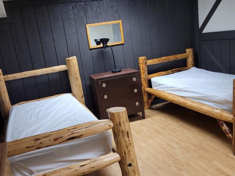 Sleeping barracks with 3 twin beds with a closed door.