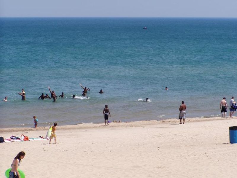 A family playing football on the shore at West Beach