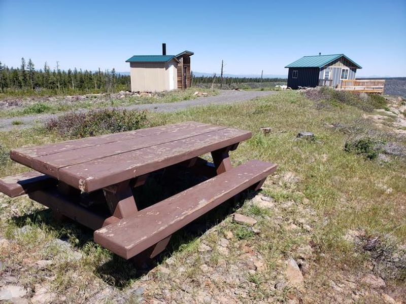 View of Cabin, Outhouse, Woodshed, and Picnic Table