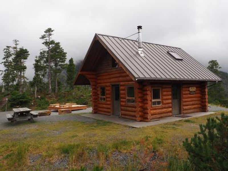 Middle Ridge Cabin exterior with picnic table and tent platform