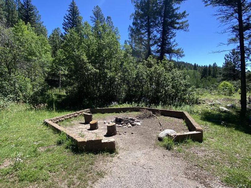 A metal fire ring with brick walls surround this area, ideal for large groups.