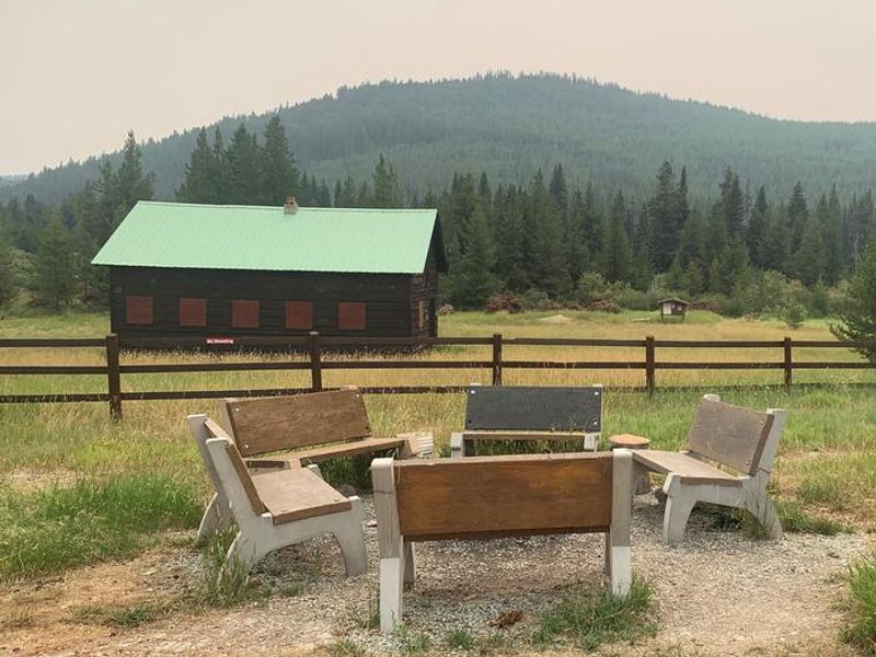 Back yard fire pit with benches. Historic barn and NFST 171A trailhead in background. 