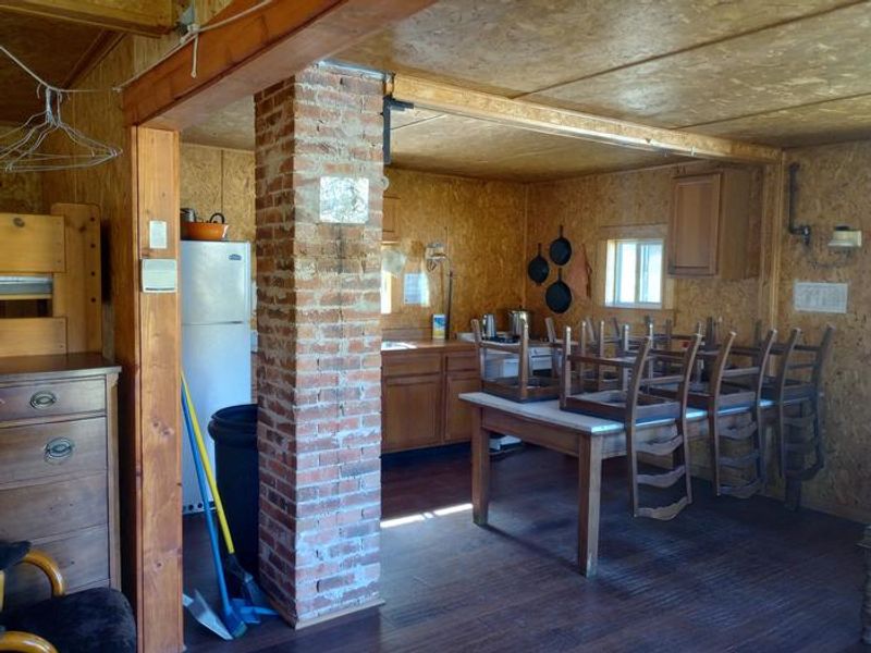 Open cabin with kitchen including propane powered fridge and stove. Sink available but water is from exterior well.