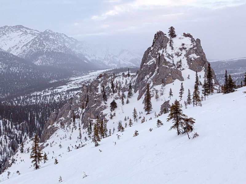 A rocky limestone spire dominates the rugged landscape near Windy Gap in the White Mountains.